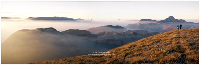 Looking south over the 2,000 meter high Eravikulam plateau from Kattu Malai. The sunrise highlights the extensive “downs” of the shola/grasslands complex that is uniquely preserved in this magical National Park. Anai Mudi’s distinctive hat profile is on the right horizon while the edges of the Palalni Hills are on the far left. My father Merrick and cousin Anna are at the edge taking in an unforgettable Western Ghats experience.